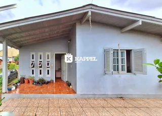Fachada externa de uma residência em Lajeado, Brasil, com varanda coberta e janelas com venezianas.