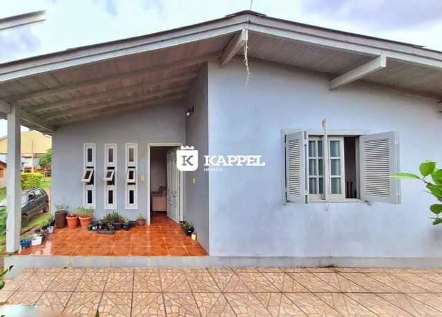 Fachada externa de uma residência em Lajeado, Brasil, com varanda coberta e janelas com venezianas.