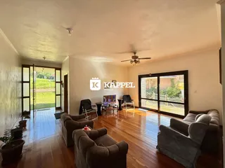 Sala de estar com piso de madeira e acesso a área externa.