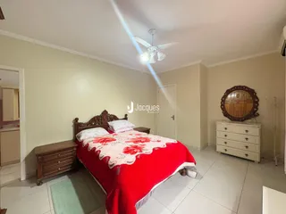 Quarto com cama de madeira e cabeceira decorativa em uma residência.