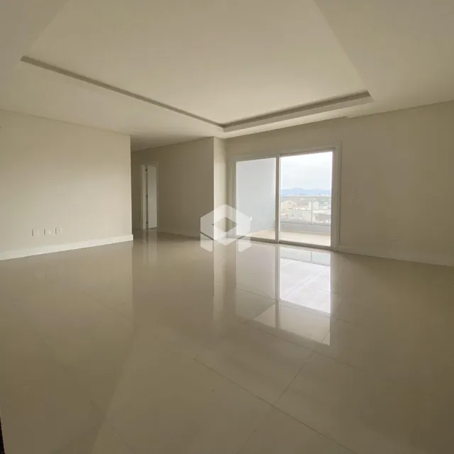 Ambiente interno amplo com piso claro e paredes brancas.