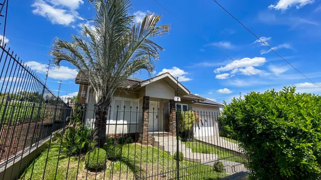 Fachada de uma residência com cerca e vegetação em Lajeado, Brasil.