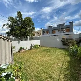 Foto da área externa com gramado e muro de uma propriedade em Lajeado.