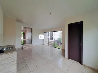 Sala ampla com piso de cerâmica clara e acesso a área externa.