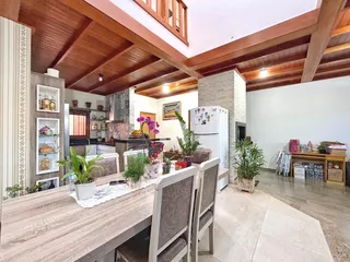Sala de jantar com piso de cerâmica e teto de madeira em imóvel no Brasil.