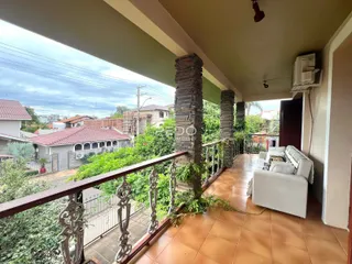 Vista de uma varanda coberta com piso de cerâmica e grade de ferro na Lajeado.