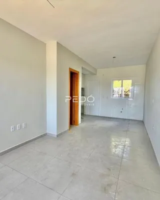 Hall de entrada com piso claro e paredes brancas em uma residência.