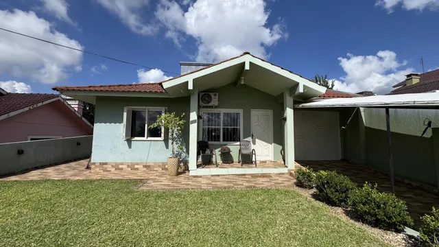 Foto da fachada de uma casa em Lajeado, Brasil, com jardim gramado na frente.