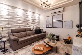 Sala de estar moderna com sofá e decoração de parede.