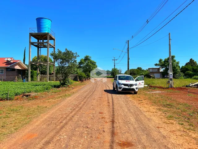 Vista de uma estrada de terra rural em Lajeado, Brasil, com vegetação ao redor.
