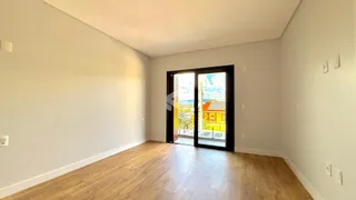 Interior de uma sala com piso de madeira e porta de vidro.