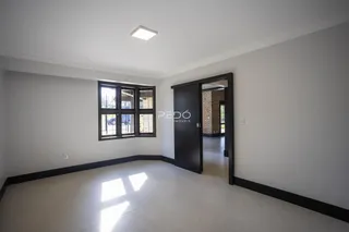Ambiente interno de uma sala com piso claro e janela.