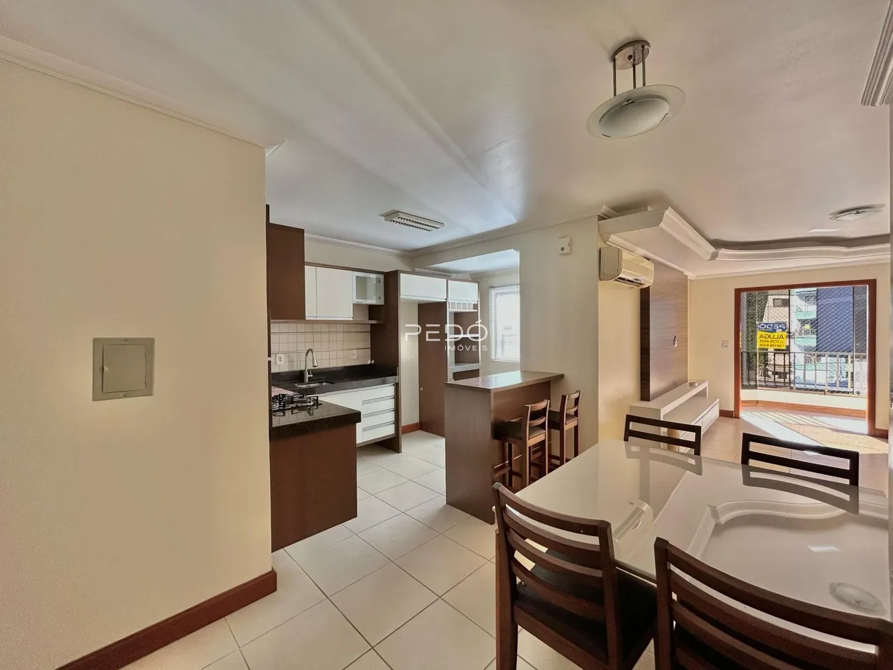Ambiente interno de uma sala de estar com cozinha e área de jantar em Lajeado.