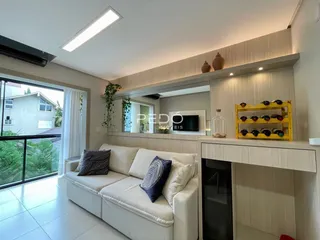 Sala de estar iluminada com grandes janelas que dão vista para o exterior.