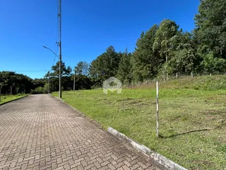 Vista da propriedade com campo gramado e estrada.