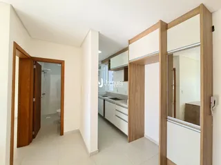Hall de entrada com portas de madeira e paredes brancas.