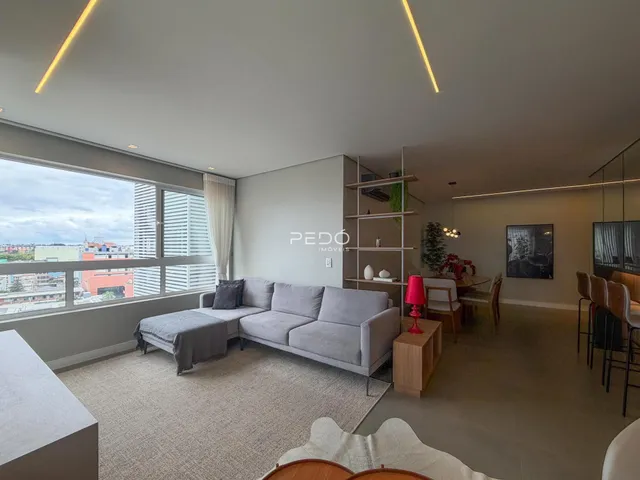 Sala de estar ampla com vista para a paisagem urbana.