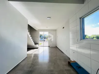 Hall de entrada com piso de cerâmica e paredes brancas.