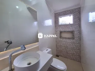 Banheiro com pia branca e revestimento decorativo na parede.