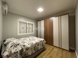 Quarto com cama e armários de madeira em um imóvel no Brasil.