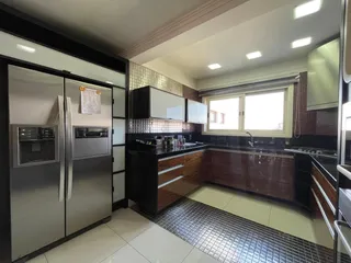 Foto de uma cozinha moderna com armários escuros e bancadas escuras.