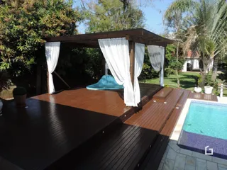 Deck de madeira com vista para a piscina ao ar livre.