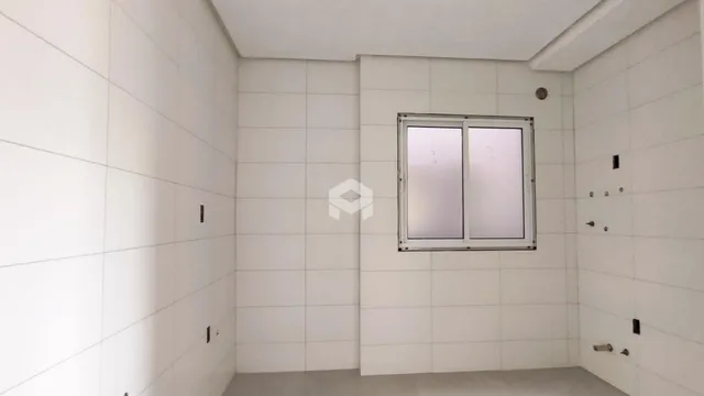 Parede interna branca com janela em um ambiente residencial.