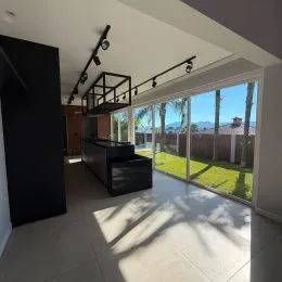 Vista da área interna com grande janela voltada para o jardim.