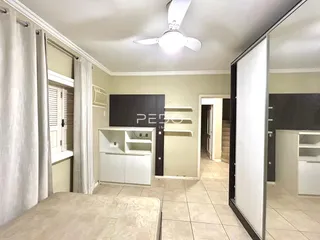 Quarto com paredes brancas e piso de cerâmica em uma residência.
