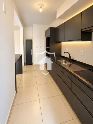 Vista de um corredor interno com piso claro e armários escuros.