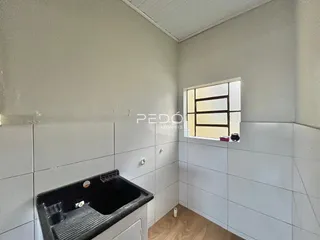 Foto de um ambiente interno com paredes brancas e piso de madeira clara.