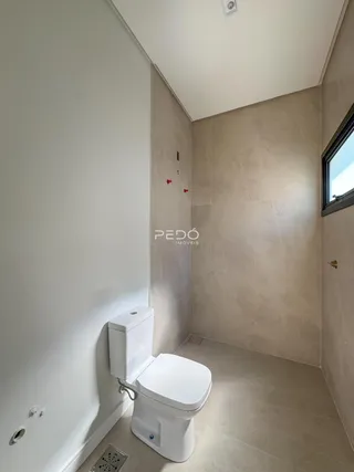 Banheiro com revestimento de pedra nas paredes.
