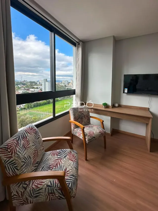 Sala de estar com grande janela e piso de madeira.