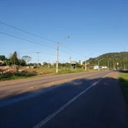 Vista de uma estrada pavimentada em Lajeado, Brasil, sob um céu azul claro.