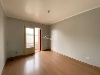 Sala de estar com piso de madeira e porta de vidro abrindo para o exterior.