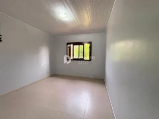 Foto de um cômodo interno com paredes brancas e piso de cerâmica.