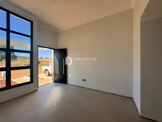 Vista interna de um ambiente com piso de cerâmica e paredes brancas.