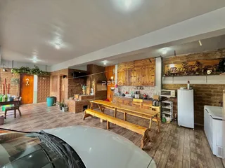 Ambiente interno de sala de estar com piso de madeira e detalhes em tijolo aparente.