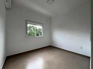 Uma sala de estar ampla com piso de cerâmica e janela.