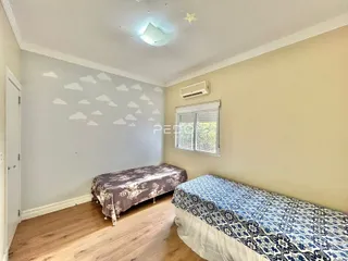 Quarto com piso de madeira e paredes claras.