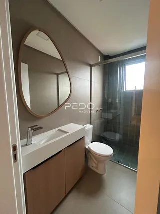 Foto de um banheiro com bancada e box de vidro em um imóvel.