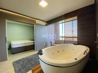 A imagem exibe um banheiro com uma banheira oval e uma vista para o quarto.