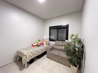 Quarto com cama e sofá em ambiente claro.