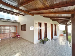 Sala ampla com piso de cerâmica e forro de madeira exposto.