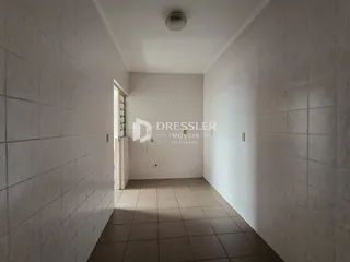 Corredor interno com piso de cerâmica e paredes brancas.