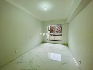 Uma sala de estar com piso de mármore claro e paredes brancas.