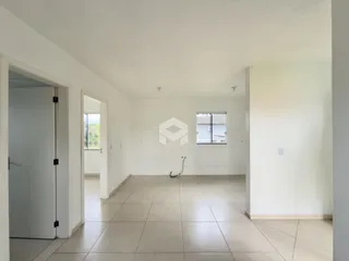 Corredor interno de uma residência com paredes brancas e piso claro.