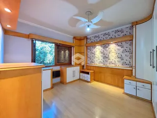 Ambiente interno de sala com piso de madeira clara e painéis decorativos.