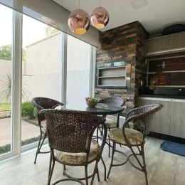 Foto de uma área de jantar com mesa e cadeiras em um ambiente com vista externa.