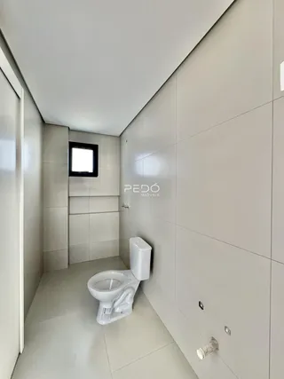 Foto de um banheiro moderno com revestimento branco e piso claro.